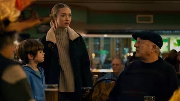 Mickey Fitzpatrick (Amanda Seyfried) stands with a boy and an older man in a restaurant