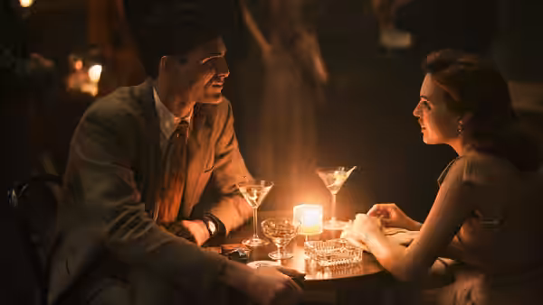 Dorrigo Evans (Jacob Elordi) and Amy Mulvaney (Odessa Young) talk over drinks at a candlelit table