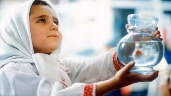 Razieh (Aida Mohammadkhani) holds a glass fishbowl and looks up