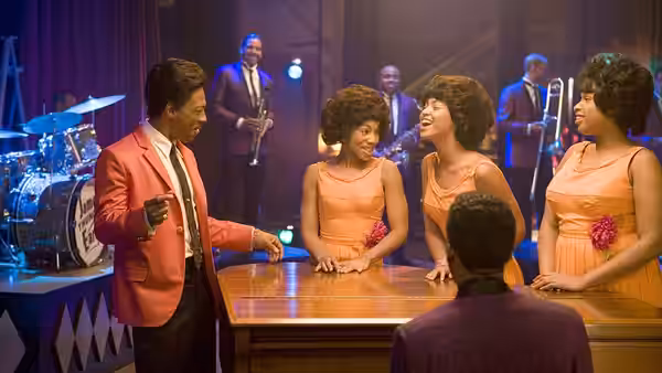 Curtis Taylor Jr. talks with the Dreamettes at a rehearsal-room table