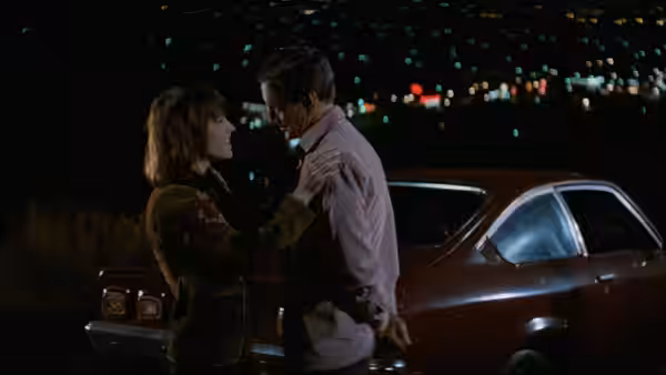 Kate (Candy Clark) and Murphy (Roy Scheider) talk beside a car at night