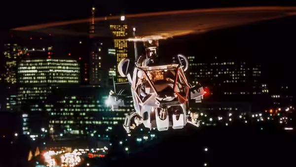 The Blue Thunder helicopter flies above the city lights at night