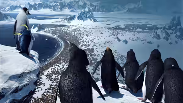 A group of penguins gathers on a snowy ridge above a frozen Antarctic coastline