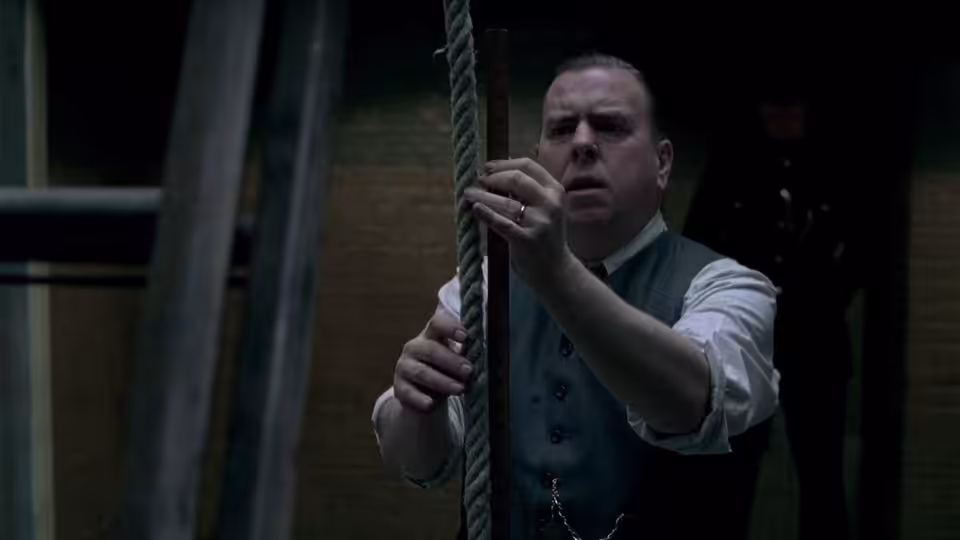 Albert Pierrepoint (Timothy Spall) adjusts a hanging rope in the execution chamber
