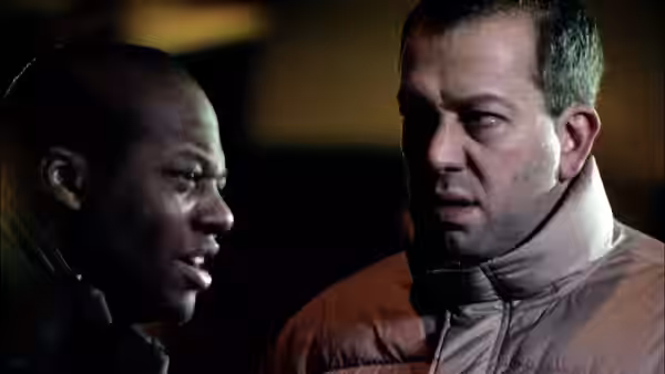 A man speaks to an injured man wearing a neck brace