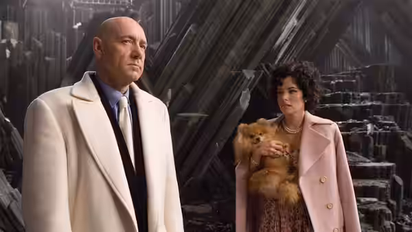 Lex Luthor (Kevin Spacey) stands beside Kitty Kowalski (Parker Posey), who holds a small dog