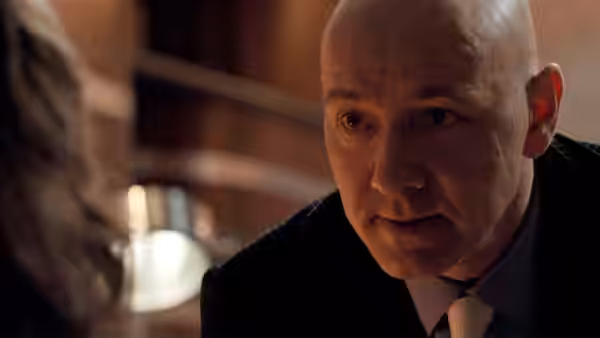 Lex Luthor (Kevin Spacey) speaks to someone across a table
