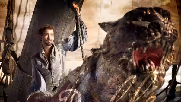 Sir Walter Raleigh (Clive Owen) holds a ship's rigging beside a carved figurehead