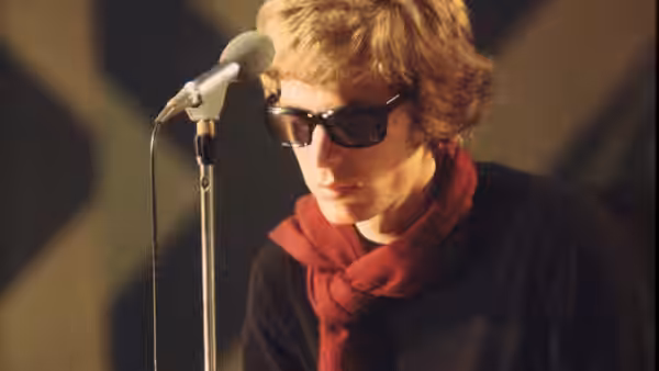 Scott Walker (Scott Walker) wearing sunglasses and a red scarf at a microphone