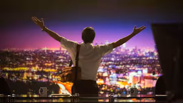 Louis Bloom (Jake Gyllenhaal) with arms outstretched before a city skyline