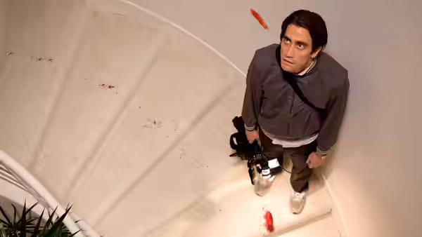 Louis Bloom (Jake Gyllenhaal) on a blood-stained spiral staircase with camera gear