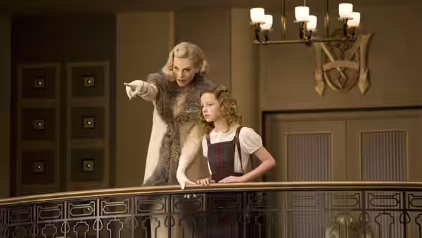 Marisa Coulter (Nicole Kidman) points from a balcony beside Lyra Belacqua