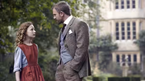 Lyra Belacqua speaks with Lord Asriel (Daniel Craig) in a garden