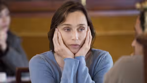 Juliette (Kristin Scott Thomas) rests her face in her hands at a table