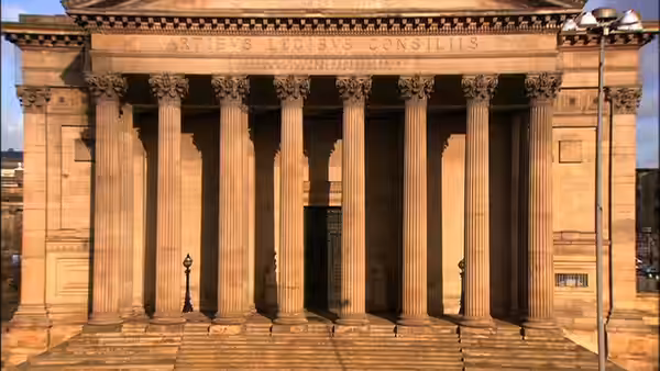 Tall columns frame the entrance to a grand neoclassical building