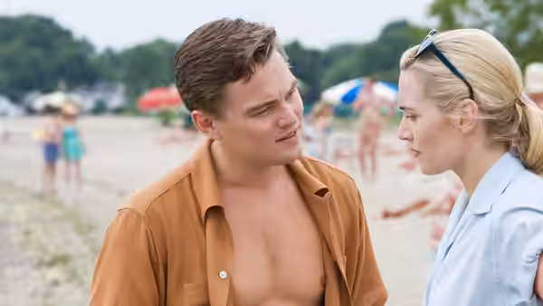 Frank Wheeler (Leonardo DiCaprio) talks with April on a crowded beach