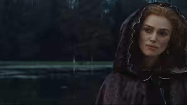 Georgiana Cavendish (Keira Knightley) wears a dark hooded cloak beside a pond
