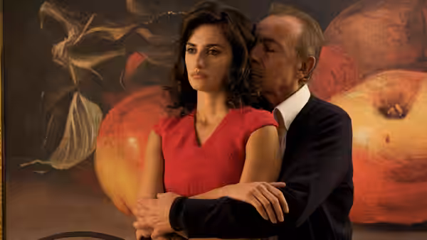 Lena (Penélope Cruz) stands with Ernesto Martel (José Luis Gómez) embracing her from behind