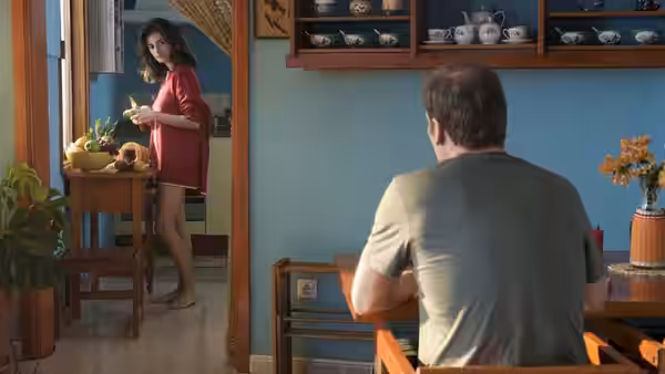 Lena (Penélope Cruz) stands in a doorway as a man sits at the table