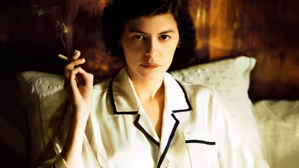 Gabrielle 'Coco' Chanel (Audrey Tautou) sits in bed wearing pajamas and holding a cigarette