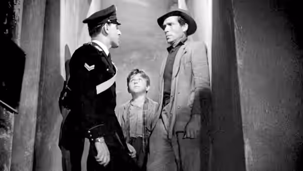 Antonio and Bruno face a uniformed officer in a doorway