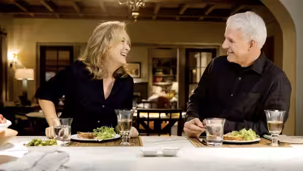 Jane Adler (Meryl Streep) laughs with a white-haired man over dinner