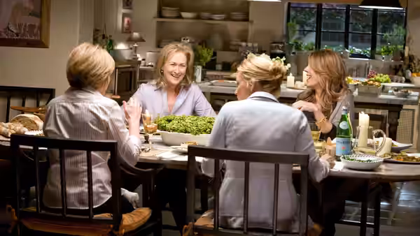 Jane Adler (Meryl Streep) shares a meal with friends around a kitchen table