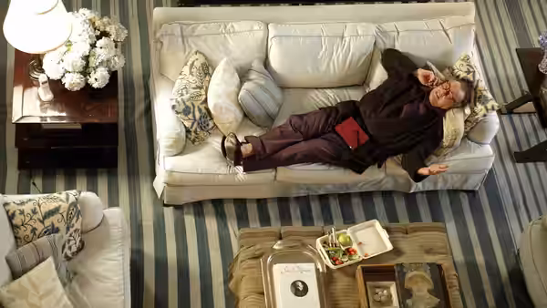 Harry Sanborn reclines alone on a sofa in a living room
