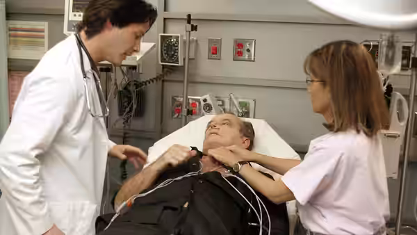 Julian Mercer (Keanu Reeves) and a nurse tend to Harry Sanborn in a hospital bed