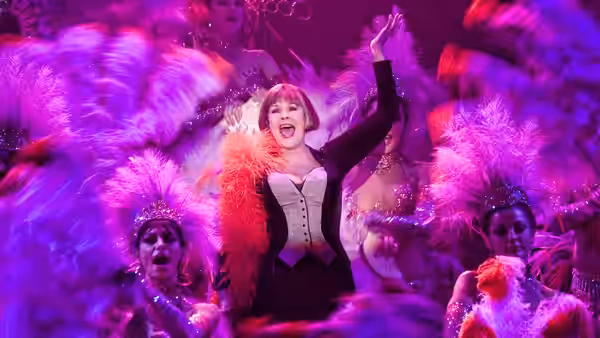 Lilli (Judi Dench) sings onstage among dancers in feathered costumes