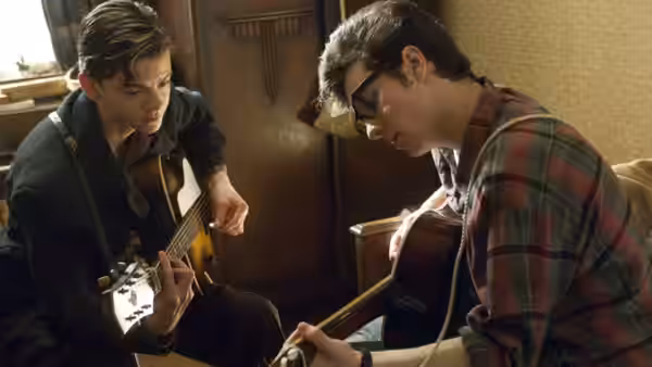 John Lennon (Aaron Taylor-Johnson) and Paul McCartney (Thomas Brodie-Sangster) play guitars together indoors