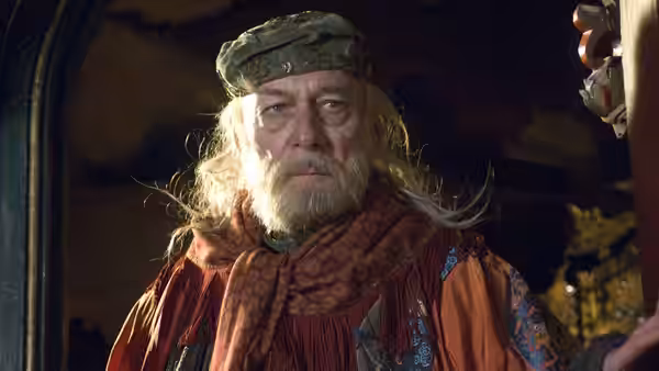Doctor Parnassus (Christopher Plummer) stands in ornate robes beneath a dark canopy