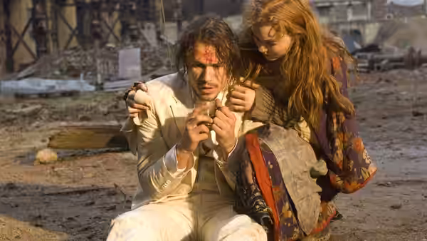 Tony (Heath Ledger) examines a small object while Valentina (Lily Cole) leans over him