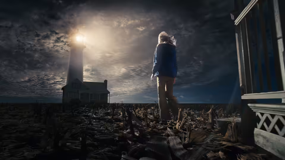 A girl in a blue coat stands among dark branches beneath a glowing lighthouse