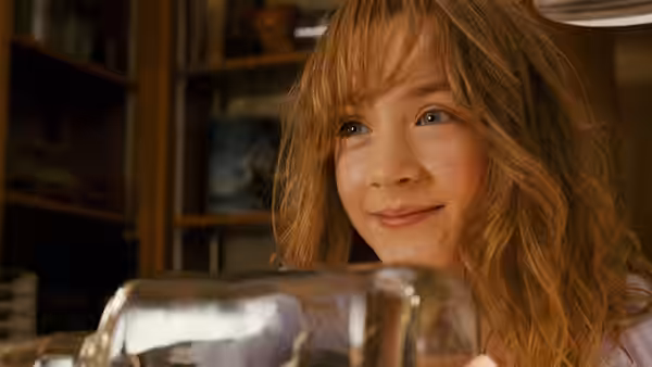Susie Salmon (Saoirse Ronan) smiles while holding a small glass model