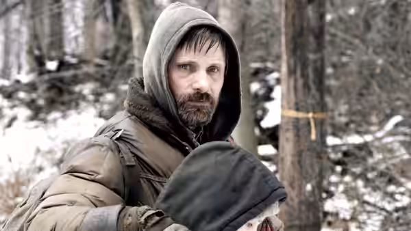 The Father holds the Boy close in a snowy woodland