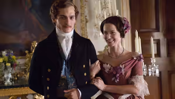 Prince Albert (Rupert Friend) stands arm in arm with Queen Victoria (Emily Blunt) in a palace room