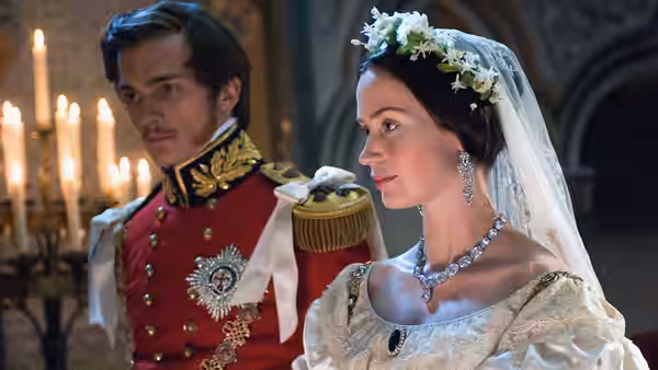 Queen Victoria (Emily Blunt) stands beside Prince Albert (Rupert Friend) in a candlelit church
