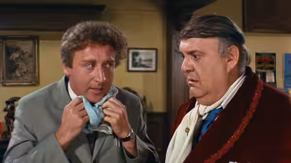 Leo Bloom adjusts his bow tie while Max Bialystock watches him closely