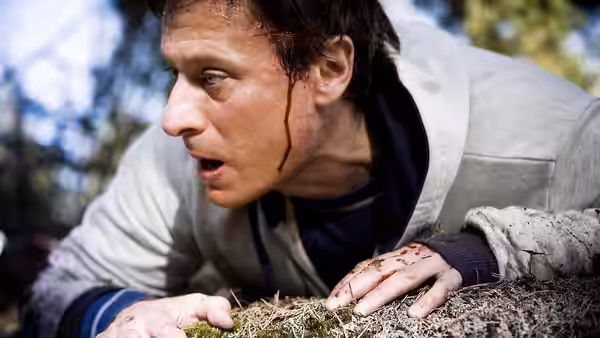 Mikael Blomkvist (Michael Nyqvist) lies wounded on the forest floor