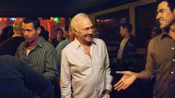 Hal (Christopher Plummer) smiles among guests at a crowded party