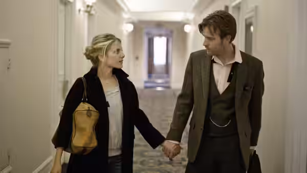 Anna (Mélanie Laurent) and Oliver (Ewan McGregor) hold hands while walking down a hallway