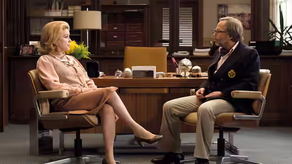 Suzanne Pujol (Catherine Deneuve) and Maurice Babin (Gérard Depardieu) face each other across an office