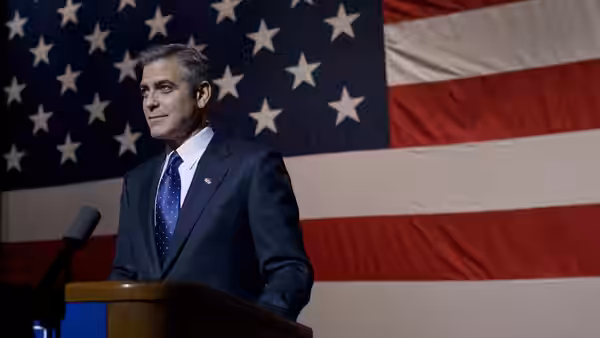 Mike Morris (George Clooney) stands at a lectern before an American flag