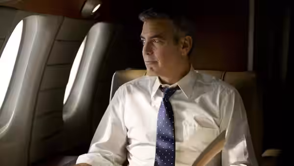 Mike Morris (George Clooney) sits belted in a private jet, looking out the window
