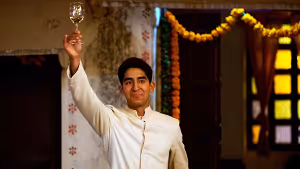 Sonny Kapoor (Dev Patel) raises a glass inside the hotel