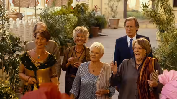 A group of hotel guests walk with an Indian woman through a courtyard