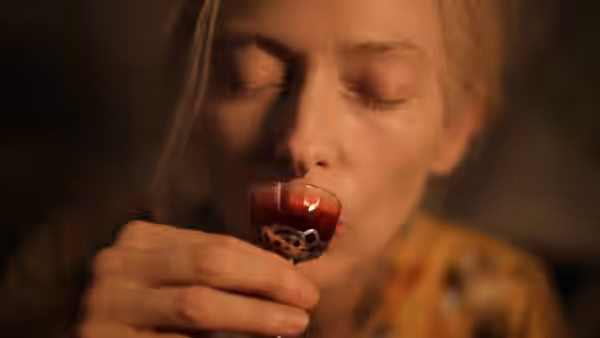 Eve (Tilda Swinton) sips red liquid from a small ornate glass