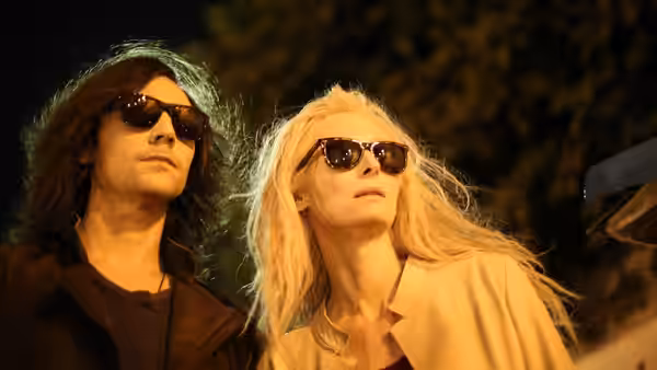 Adam (Tom Hiddleston) and Eve (Tilda Swinton) stand outside at night in sunglasses