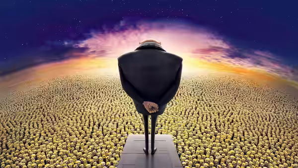 Gru (Steve Carell) stands on a platform overlooking a vast crowd of Minions at sunset